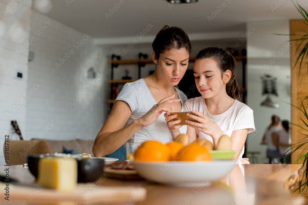 Mother and daughter looking at mobile phone