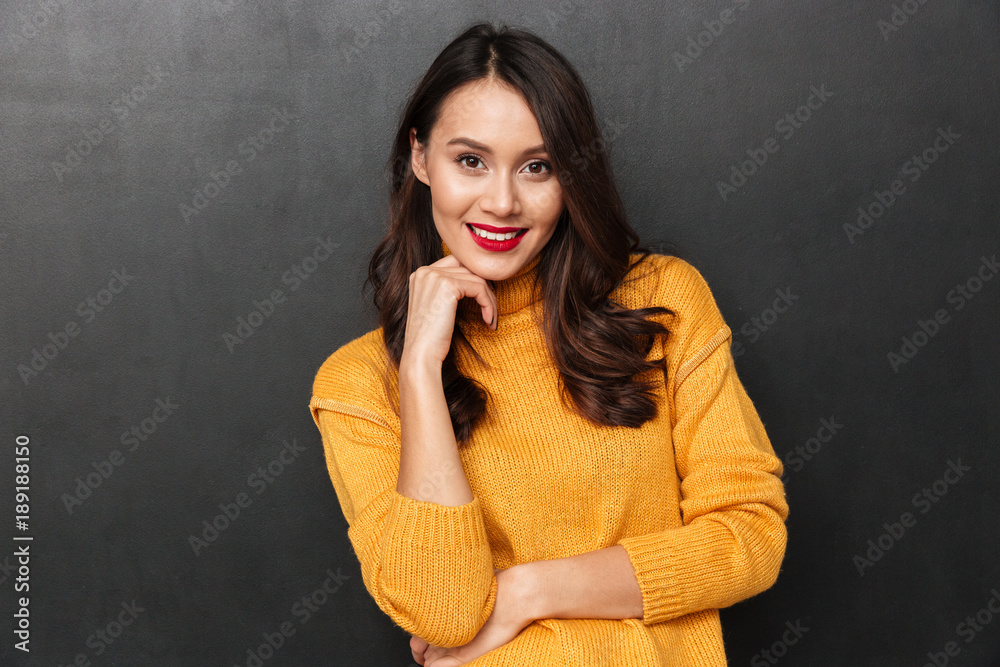 Pleased woman in sweater posing and looking at the camera Pleased woman in sweater posing and looking at the camera