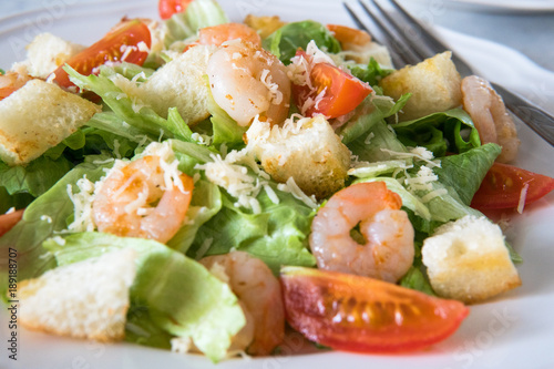 Caesar salad with shrimps, cherry tomato, croutons, salad leaf and parmesan cheese