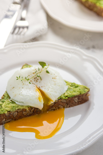 Sandwich with avocado and poached egg. Healthy breakfast