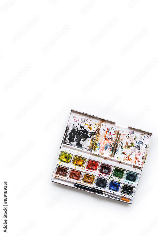 Watercolor paint travel set with a brush isolated on a white background. Vertical composition. Top view Watercolor paint travel set with a brush isolated on a white background. Vertical composition. Top view