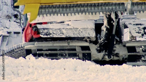 Snow machine in ski resort clears the road after a snowfall. Machine Clean the snow on the piste. Winter sport and active leisure - skiin.  photo