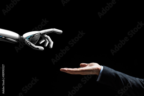 robot and human hand on black background
