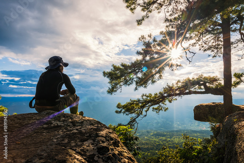 man watching the sunset from top of mountain