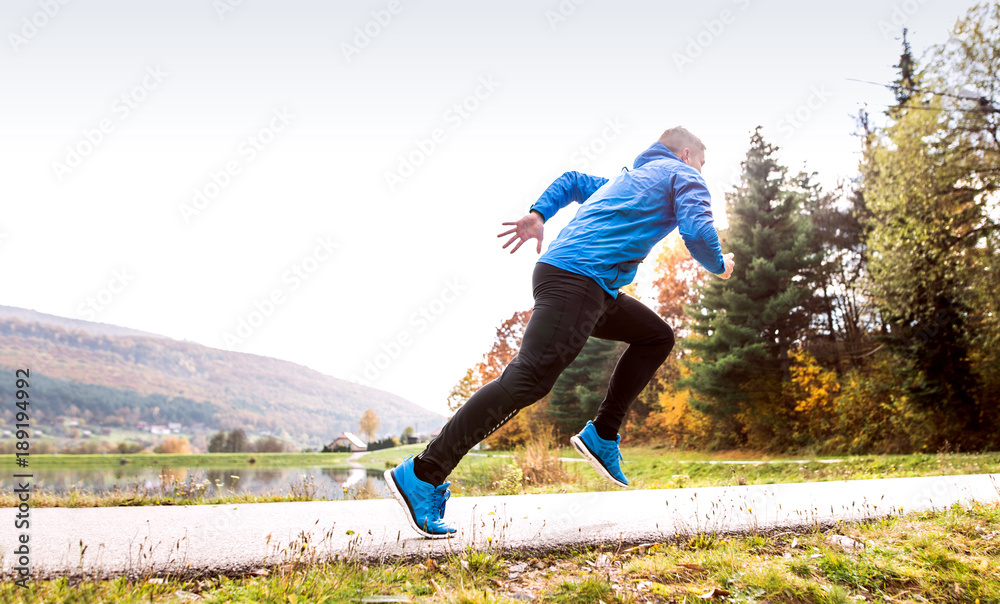 Athlete at the lake running against colorful autumn nature. Athlete at the lake running against colorful autumn nature.