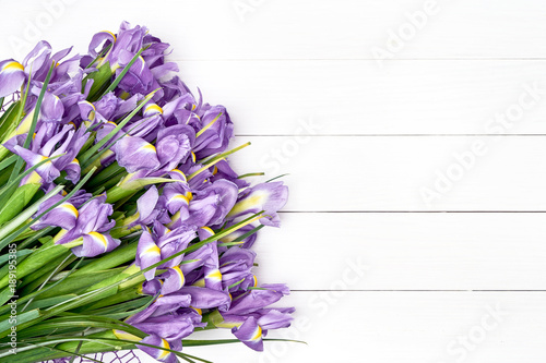 Fototapeta Naklejka Na Ścianę i Meble -  Iris bouquet on white wooden background. Holiday background. Copy space, top view.