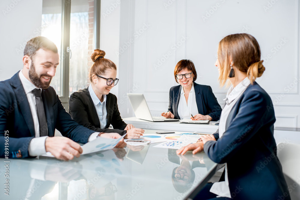 Business people working with charts and documents sitting at the table during the conference in the office