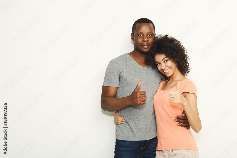 Smiling black couple in casual embracing at white studio background Smiling black couple in casual embracing at white studio background
