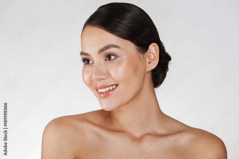 Beauty portrait of happy elegant lady with brown hair in bun smiling and looking aside, isolated over white background Beauty portrait of happy elegant lady with brown hair in bun smiling and looking aside, isolated over white background