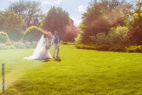 Beautiful just married couple walking in meadow © o_lypa
