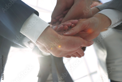 business people folding their hands together.