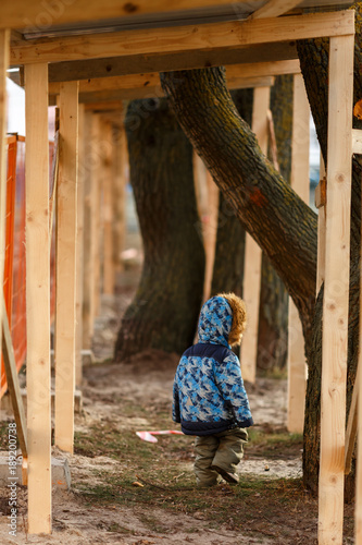 Ребёнок идёт вдоль строительного заграждения
