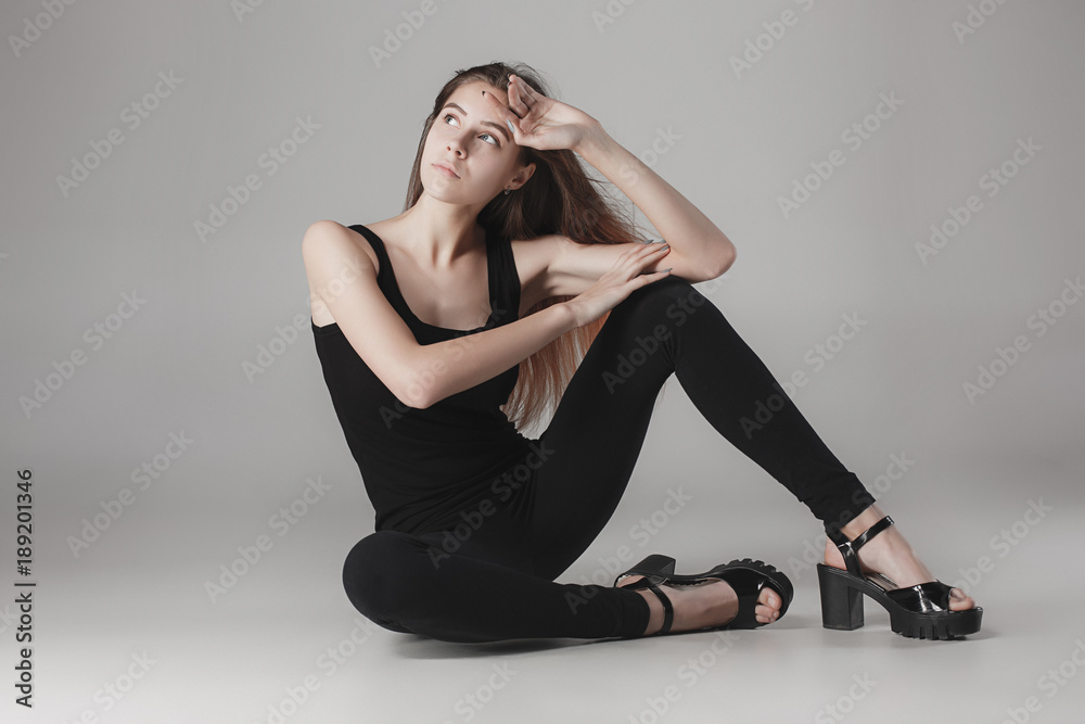 Young beautiful happy woman on gray background