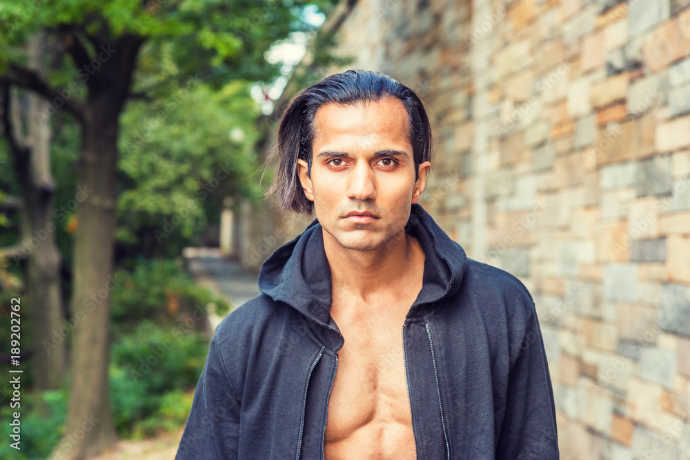 Skin American Indians Nude - Young East Indian American Man wearing black hooded outwear, opened,  showing half naked body, standing on narrow road with rock wall in New  York, looking forward.. Stock Photo | Adobe Stock