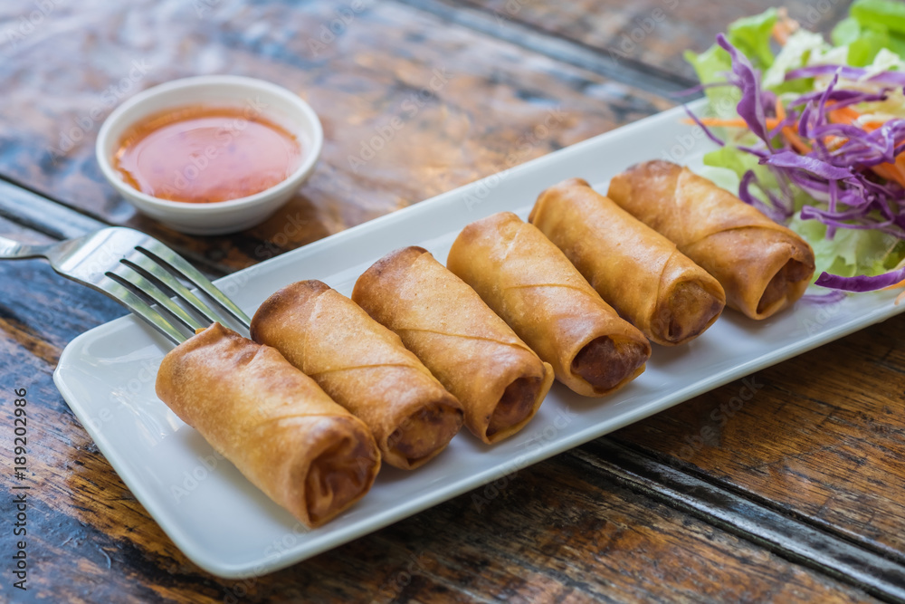 Deep fried spring rolls and vegetables on plate Deep fried spring rolls and vegetables on plate