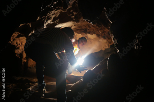 A traveler exploring a little cave with torche