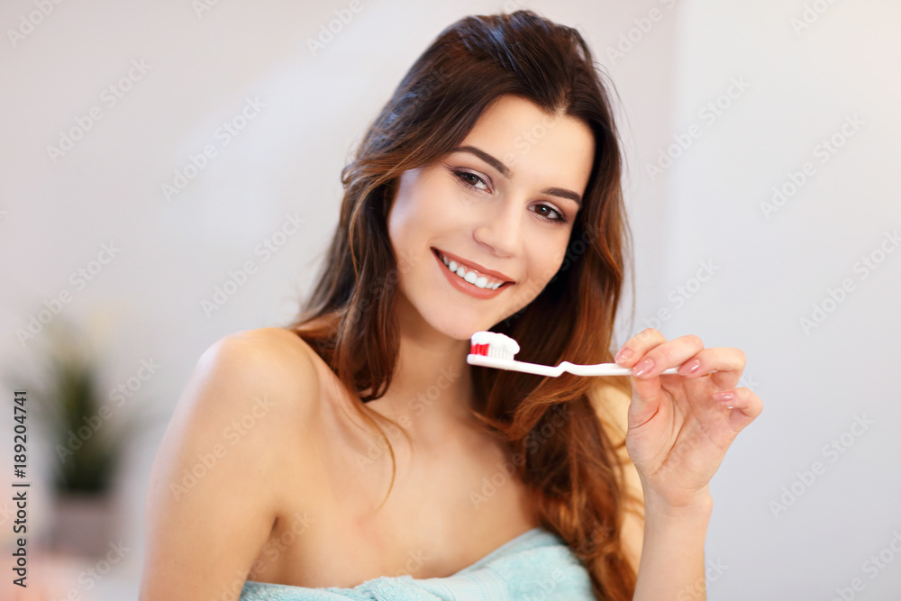 Young woman washing teeth in bathroom in the morning Young woman washing teeth in bathroom in the morning