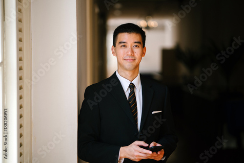 Foto Portrait of young handsome man standing in a well lit corridor