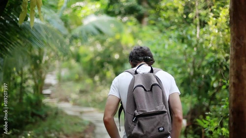 Young man backpacker walking through beautiful jungle. 1920x1080 photo