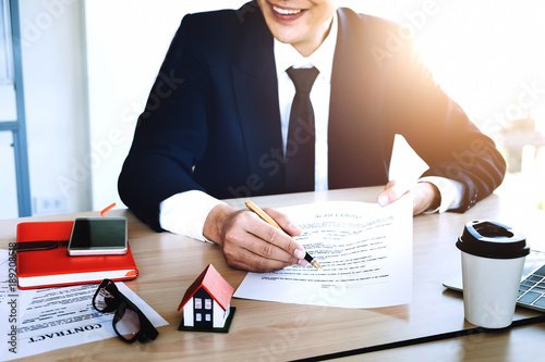 agreement paper,estate agent gives pen and documents agreement with customer to sign contract for . Concept insureance photo