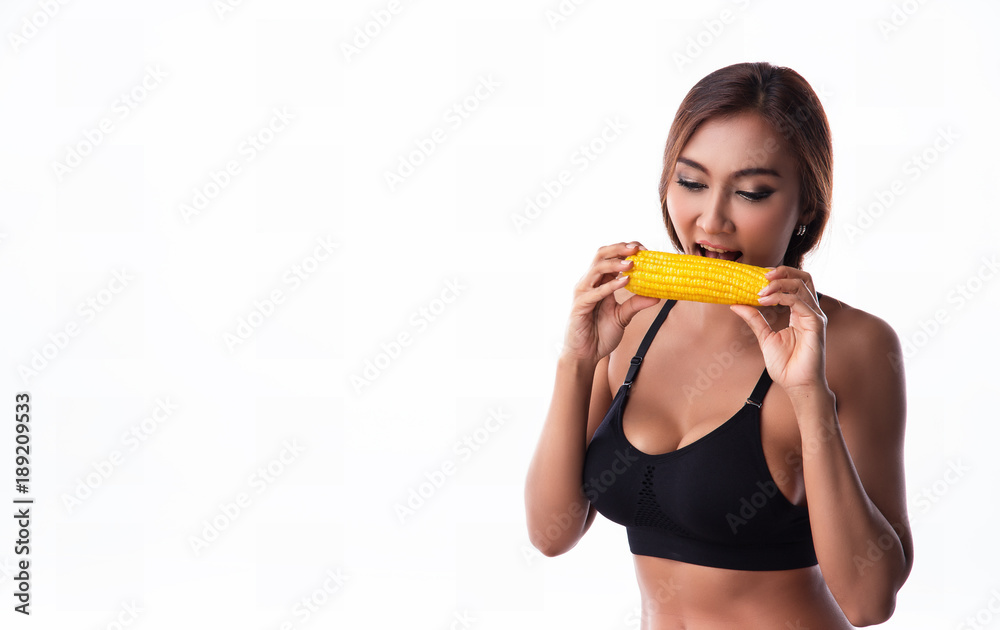The lady in exercise suit is eating yellow corn after exercise,good meal for diet and good for life The lady in exercise suit is eating yellow corn after exercise,good meal for diet and good for life