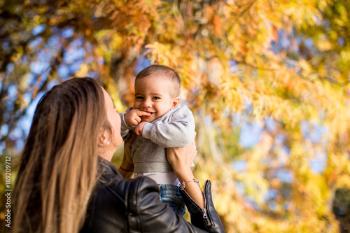 Young mother and baby boy in autumn park