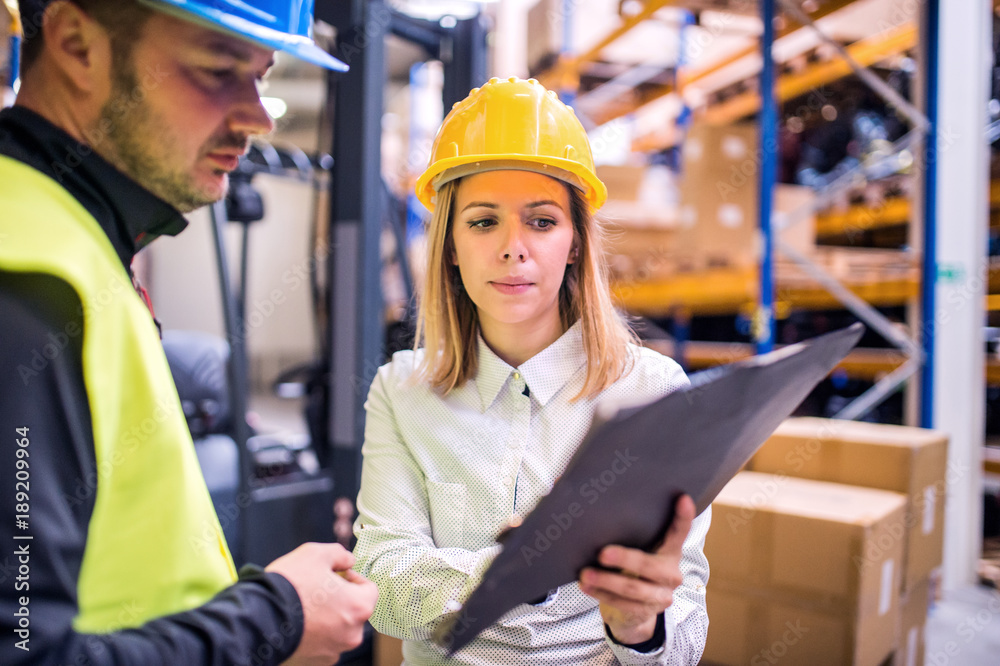 Young warehouse workers working together. Young warehouse workers working together.