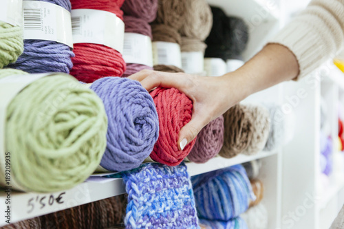 close up of a business woman picking up a pink wool yarn photo