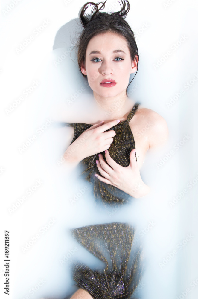 Beautiful young model girl in milk bath, relaxing, joy, rejuvenation, treatment Beautiful young model girl in milk bath, relaxing, joy, rejuvenation, treatment