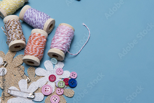 Arts and crafts background image of colourful twine with buttons and safety pins, taken with copy space 