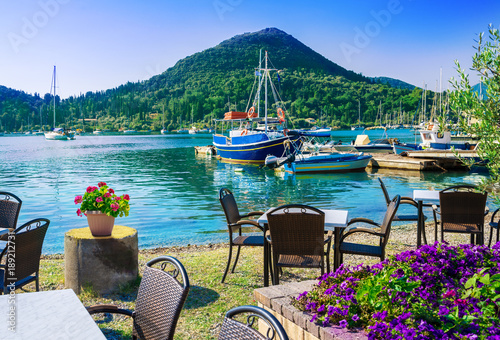 Terrace on the beach with flowers on table in Nydri village, harbour of Lefkada in Greece photo