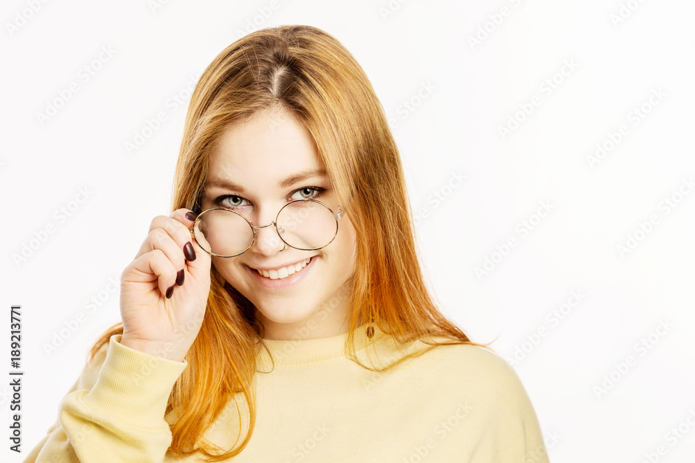 Redheaded girl-student corrects glasses