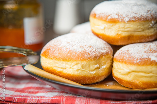 Closeup of a Group of Krapfen wih a glass of Jam