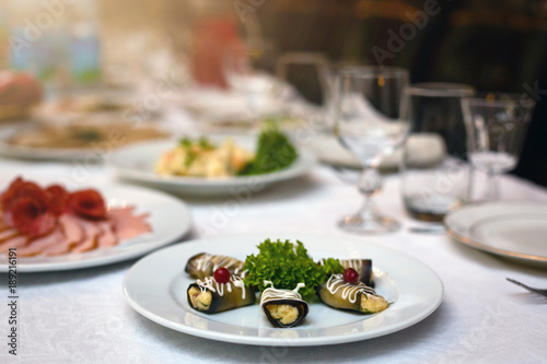 Catering eggplant rolled with cheese in white saucer