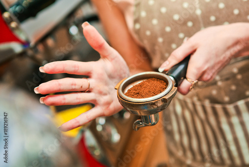barista woman prepares a holder with ground coffee