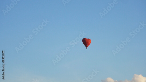 Hot air balloon shape of a heart in the blue sky. Aerostat, Airship. Red balloon. © Alex Traveler