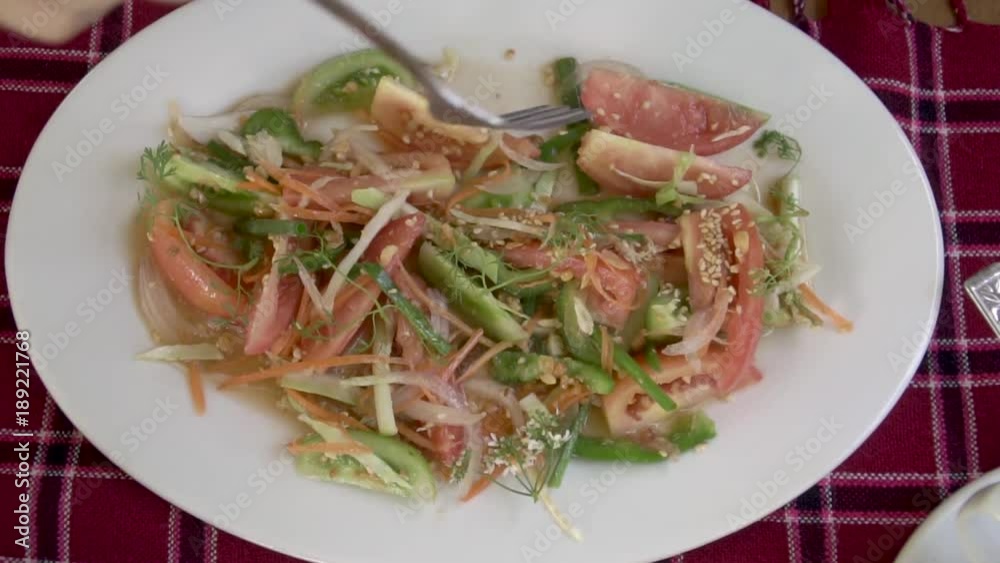 Eating Asian Vegetable Salad with Tomatoes, Pepper and Seasame. Top View Eating Asian Vegetable Salad with Tomatoes, Pepper and Seasame. Top View