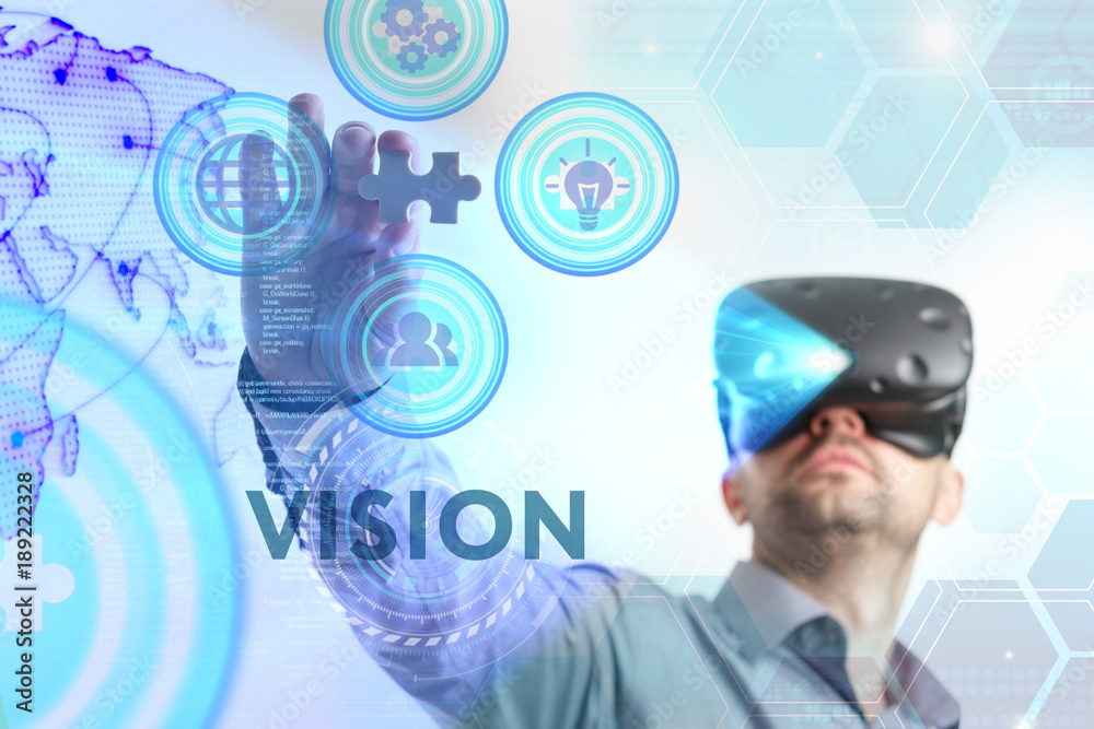 Business, Technology, Internet and network concept. Young businessman working in virtual reality glasses sees the inscription: Vision Business, Technology, Internet and network concept. Young businessman working in virtual reality glasses sees the inscription: Vision