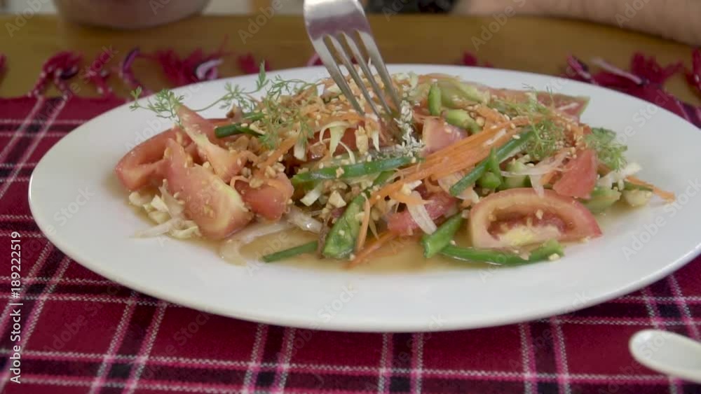 Eating Asian Salad with Tomatoes, Pepper and Seasame