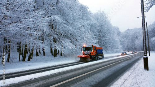 Gdynia, Poland - January 21, 2018: The snow plow clears the road in the snowy forest. © abrada