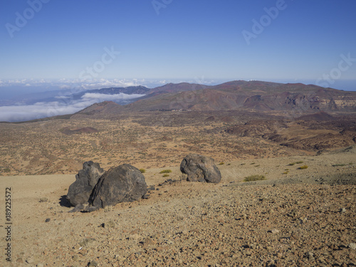 desert volcanic landscape with purple mountains in el teide national nature park with Huevos del Teide (Eggs of Teide) accretionary lava balls on clear blue sky background © Kristyna