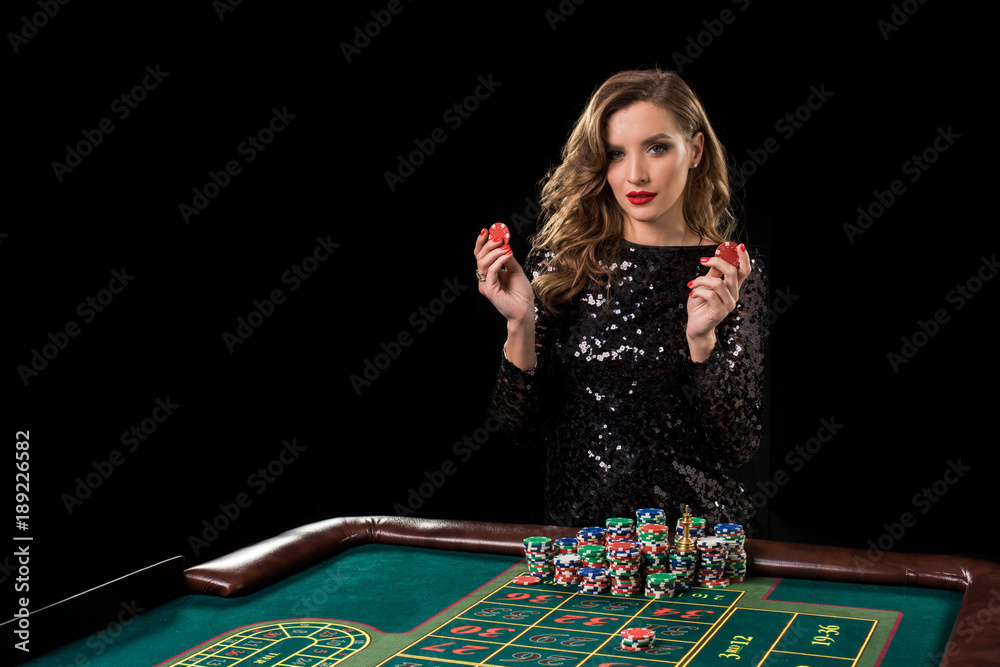 Woman playing in casino. Woman stakes piles of chips playing rou Woman playing in casino. Woman stakes piles of chips playing rou