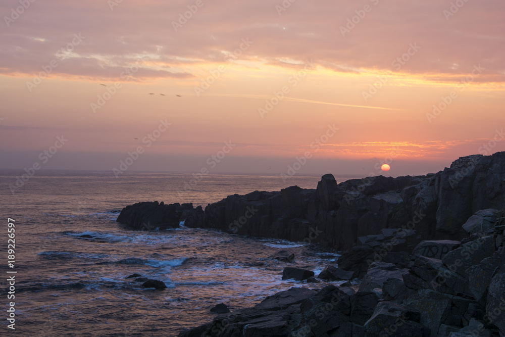 Sunrise, sunset, rocks, sea and pink clouds