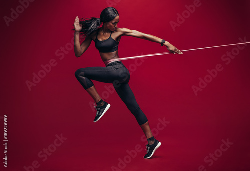 Sporty woman exercising with resistance band