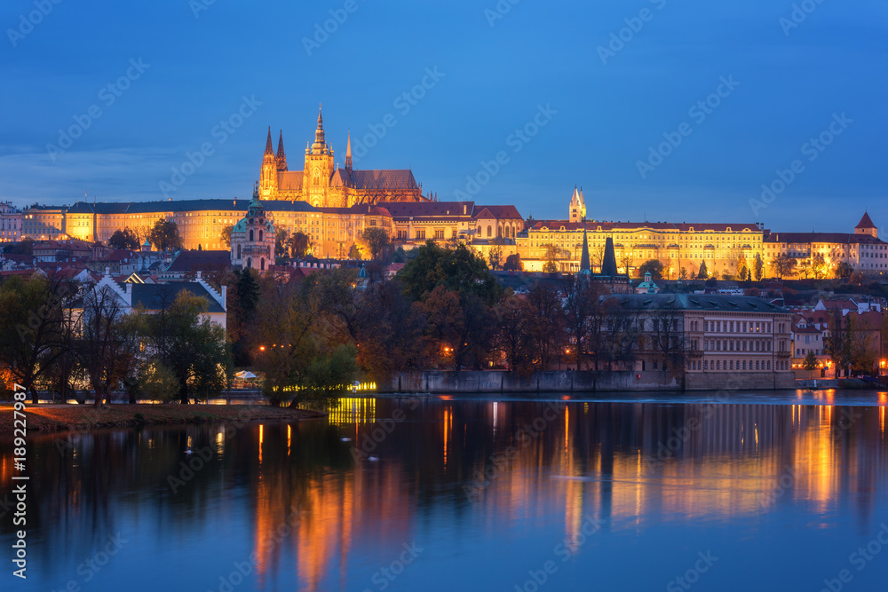 Prague, view of illuminated Prague castle (Prazsky Hrad) with reflection in the water, night scenic cityscape, world famous historical heritage of Czech Republic