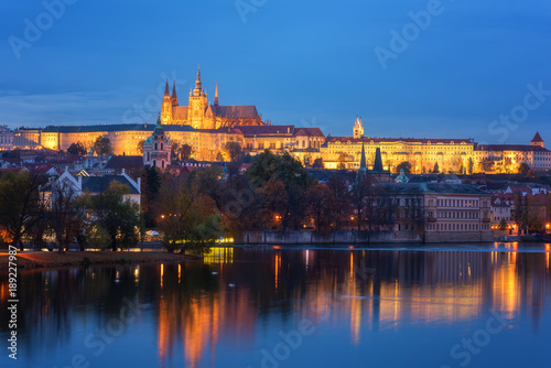 Prague, view of illuminated Prague castle (Prazsky Hrad) with reflection in the water, night scenic cityscape, world famous historical heritage of Czech Republic
