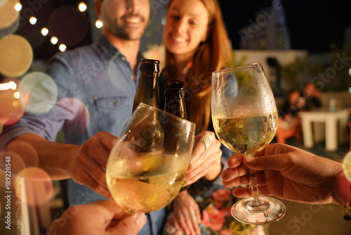 Photography Friends drinking wine at rooftop party in summertime