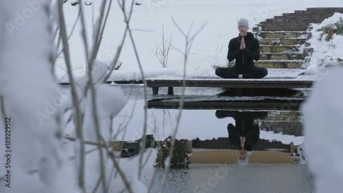 A man is meditating in nature in the winter. Yoga.