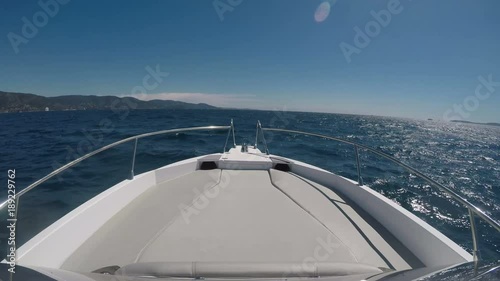 Front view of a luxury yacht navigating fast on choppy seas.