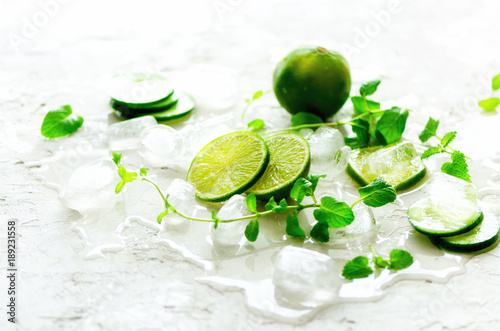 Homemade lime lemonade with cucumber, rosemary and ice, white background. Cold beverage, detox water. Copyspace. Banner